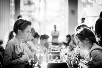 灰度摄影的孩子坐在在下棋
